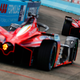 Two Formula E cars head to the grid.